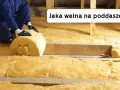 Ocieplanie poddasza wełną mineralną. Pracownik układa rolkę izolacji między drewnianymi belkami.