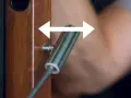 Regulacja zawiasów drzwi: klucz imbusowy obraca śrubę w drewnianej futrynie, co pozwala na precyzyjne dopasowanie.
