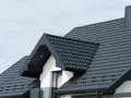 Nowy, ciemnoszary dach z blachy falistej, gotowy na wymianę dachu. Elegancki i nowoczesny wygląd domu.