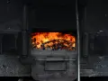 Piec kaflowy z płonącym drewnem. Czas na wymianę pieca na wsi?