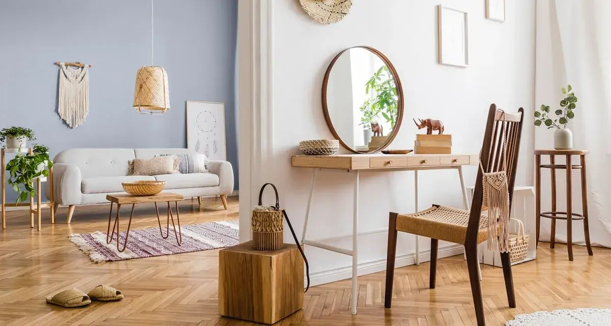 Przytulny salon z sofą i stolikiem kawowym, a obok toaletka z lustrem. Wnętrze emanuje ciepłe kolory drewna i naturalnych materiałów.