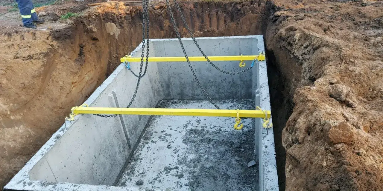 Montaż szamba betonowego 10m3. Gotowy do opuszczenia do wykopu, z żółtymi trawersami i łańcuchami. Cena z montażem.