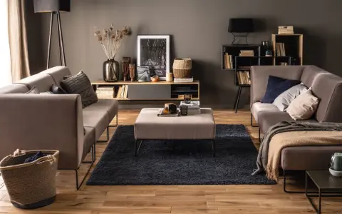 Elegancki salon z szarymi ścianami, które podkreślają ciepłe drewno podłogi i mebli. Idealne kolory ścian do salonu dla przytulnej atmosfery.