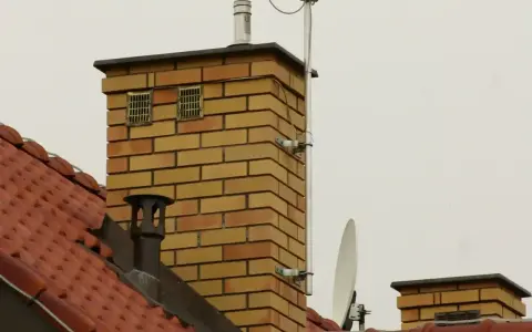 Na dachu ceglanego komina widać dwa otwory wentylacyjne, które mogą służyć jako odpowietrzenie kanalizacji. Obok znajduje się antena satelitarna.