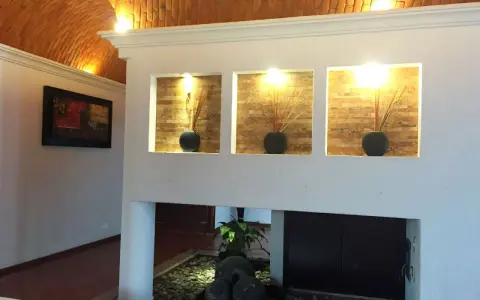 Wnęka z wazonami i patyczkami, ozdobiona kamieniami i rośliną. Nika w nowoczesnym stylu.