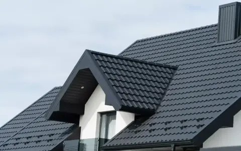 Nowy, ciemnoszary dach z blachy falistej, gotowy na wymianę dachu. Elegancki i nowoczesny wygląd domu.