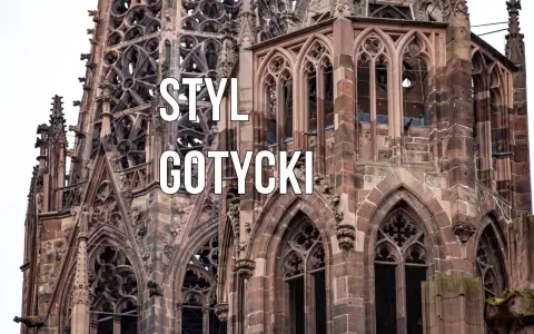 Kamienna wieża katedry w stylu **gotyckim**, z misternymi detalami i łukami.