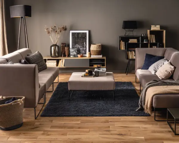 Elegancki salon z szarymi ścianami, które podkreślają ciepłe drewno podłogi i mebli. Idealne kolory ścian do salonu dla przytulnej atmosfery.
