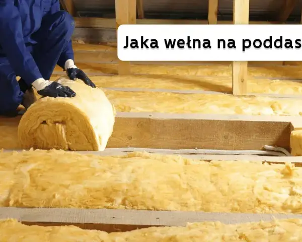 Ocieplanie poddasza wełną mineralną. Pracownik układa rolkę izolacji między drewnianymi belkami.