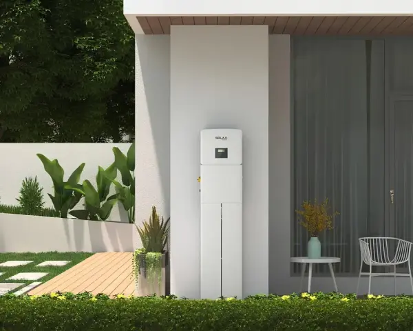 Nowoczesny magazyn energii 5 kW na ile wystarczy? Urządzenie SolaX stoi przy domu z ogrodem, oferując niezależność energetyczną.