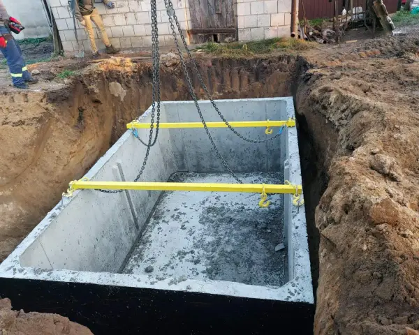 Montaż szamba betonowego 10m3. Gotowy do opuszczenia do wykopu, z żółtymi trawersami i łańcuchami. Cena z montażem.