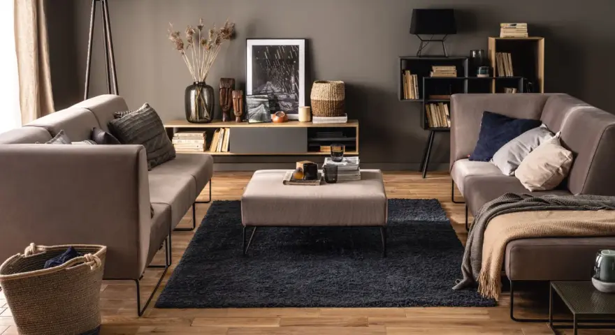 Elegancki salon z szarymi ścianami, które podkreślają ciepłe drewno podłogi i mebli. Idealne kolory ścian do salonu dla przytulnej atmosfery.