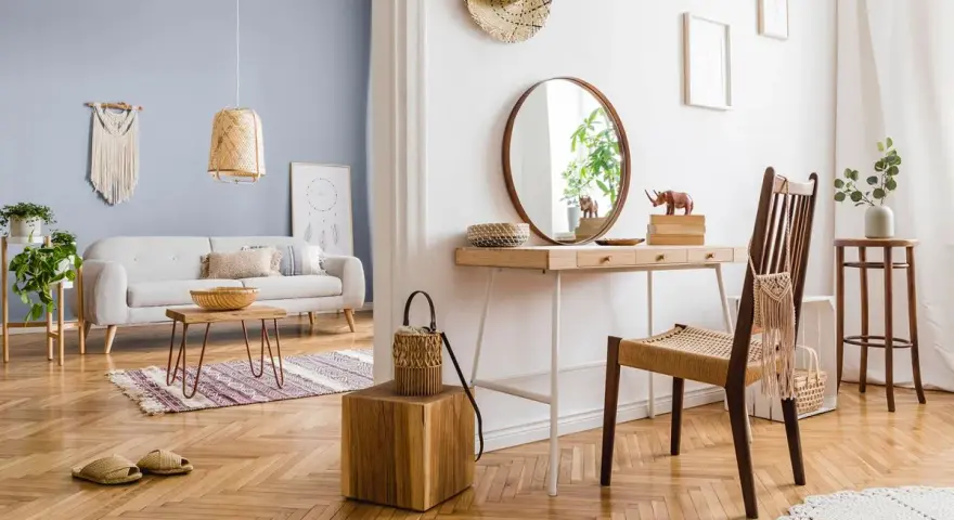 Przytulny salon z sofą i stolikiem kawowym, a obok toaletka z lustrem. Wnętrze emanuje ciepłe kolory drewna i naturalnych materiałów.