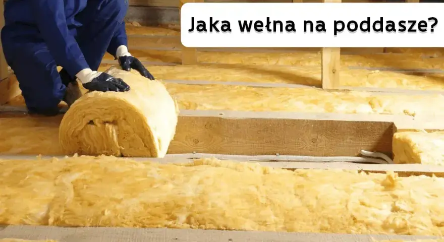 Ocieplanie poddasza wełną mineralną. Pracownik układa rolkę izolacji między drewnianymi belkami.