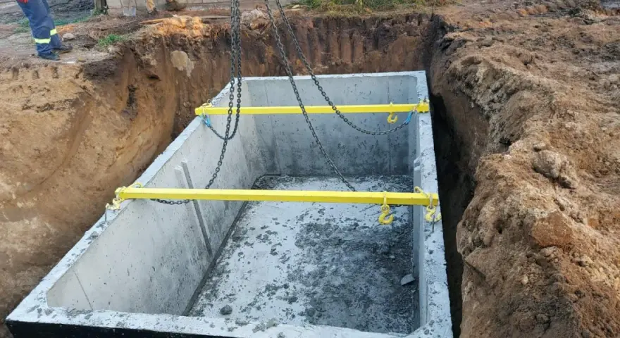 Montaż szamba betonowego 10m3. Gotowy do opuszczenia do wykopu, z żółtymi trawersami i łańcuchami. Cena z montażem.