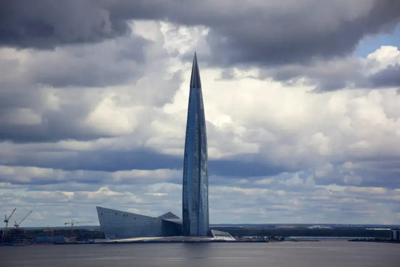 Lakhta Center, najwyższy budynek w Europie, wznosi się dumnie nad wodą, otoczony chmurami.