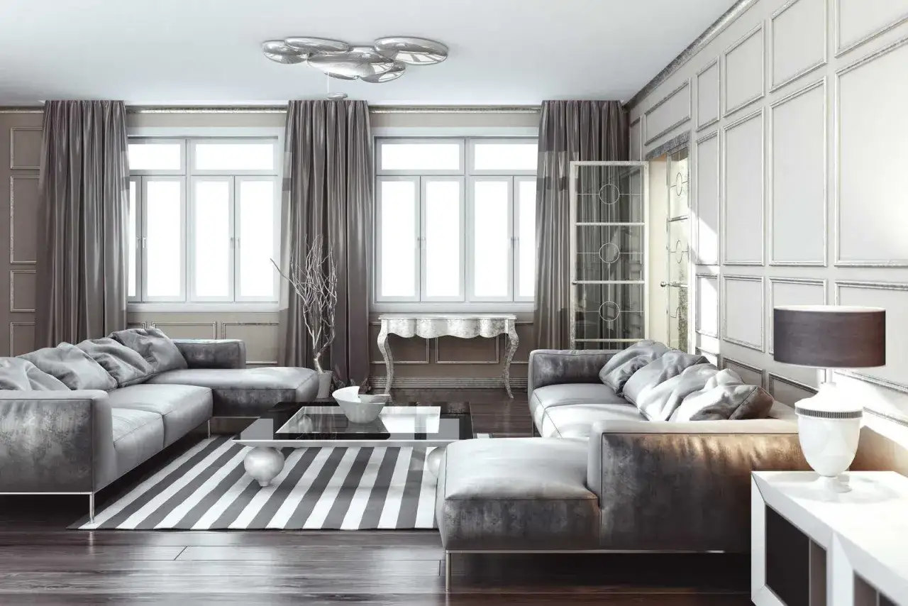 Elegancki salon z szarymi sofami, dywanem w paski i srebrzanką na ścianie.
